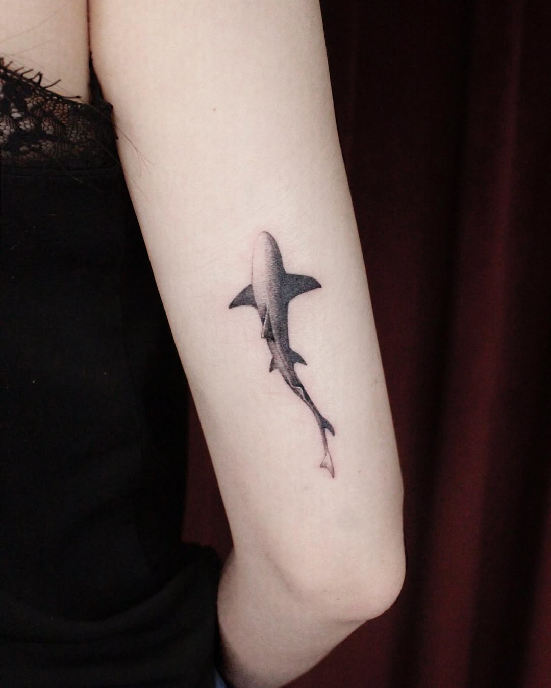 Sleek black ink shark tattoo on arm Tattoo on skin