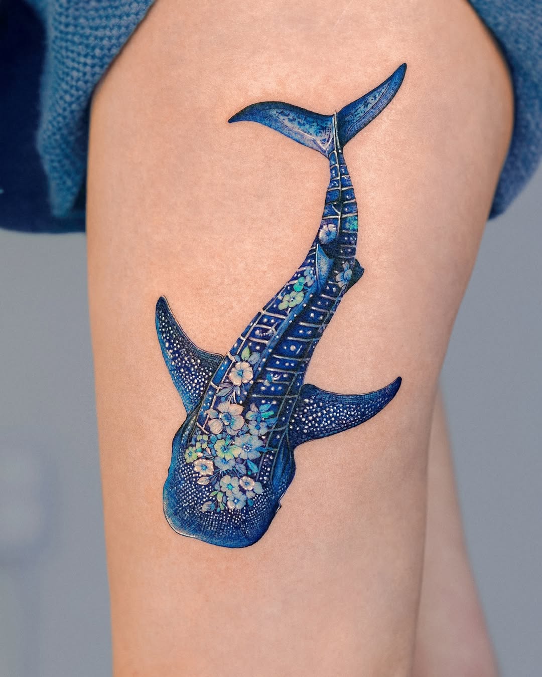 Stunning blue shark tattoo with floral accents Tattoo on skin