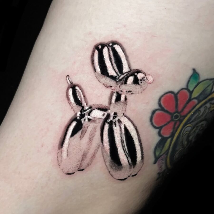 Charming balloon dog in gleaming silver ink Tattoo on skin