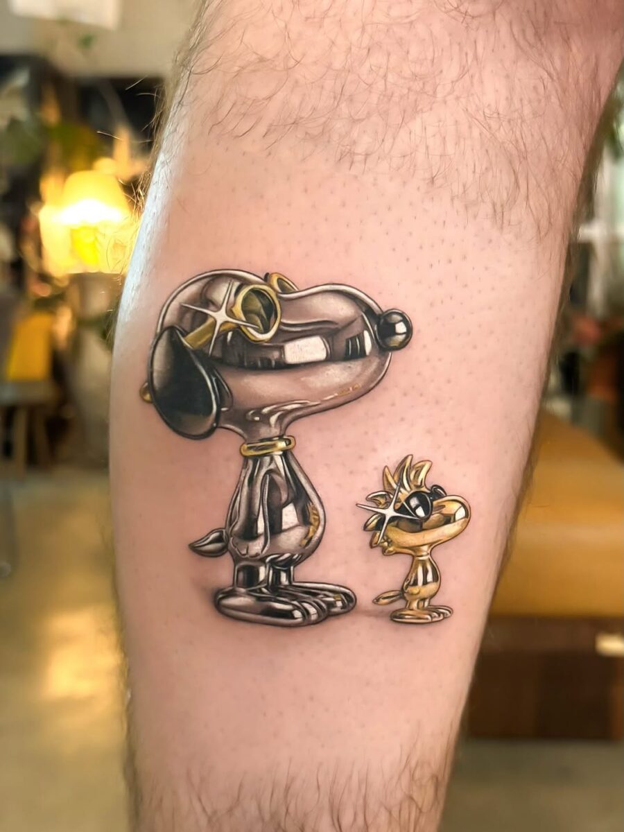 Charming silver ink tattoo of cartoon dog duo Tattoo on skin