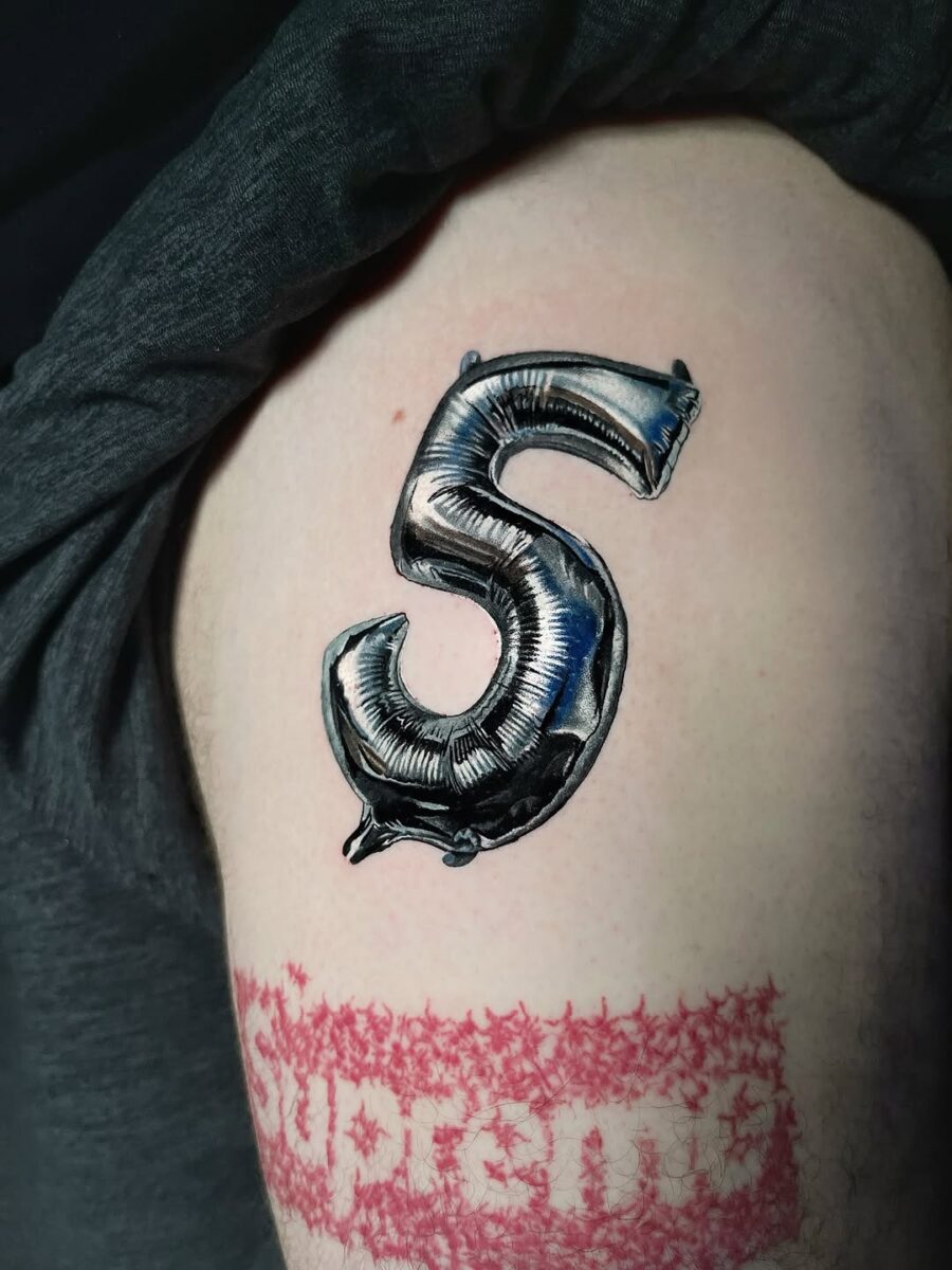 Shiny silver ink balloon number tattoo Tattoo on skin