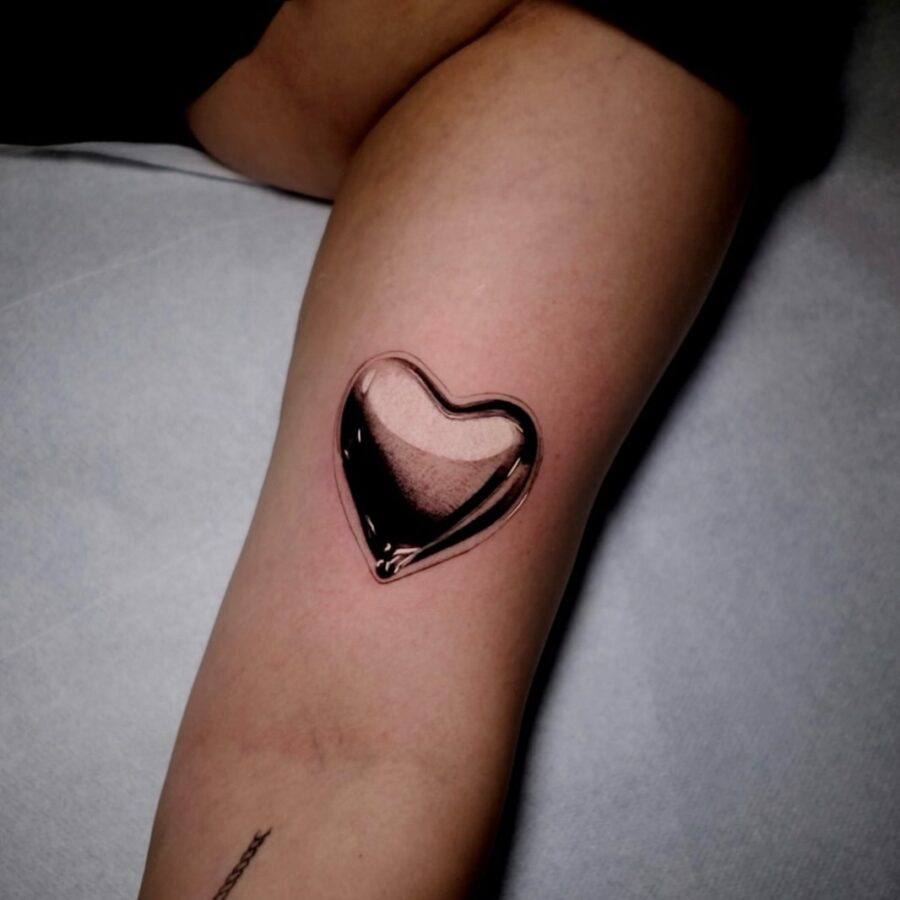 Stunning silver heart tattoo with a glossy finish Tattoo on skin