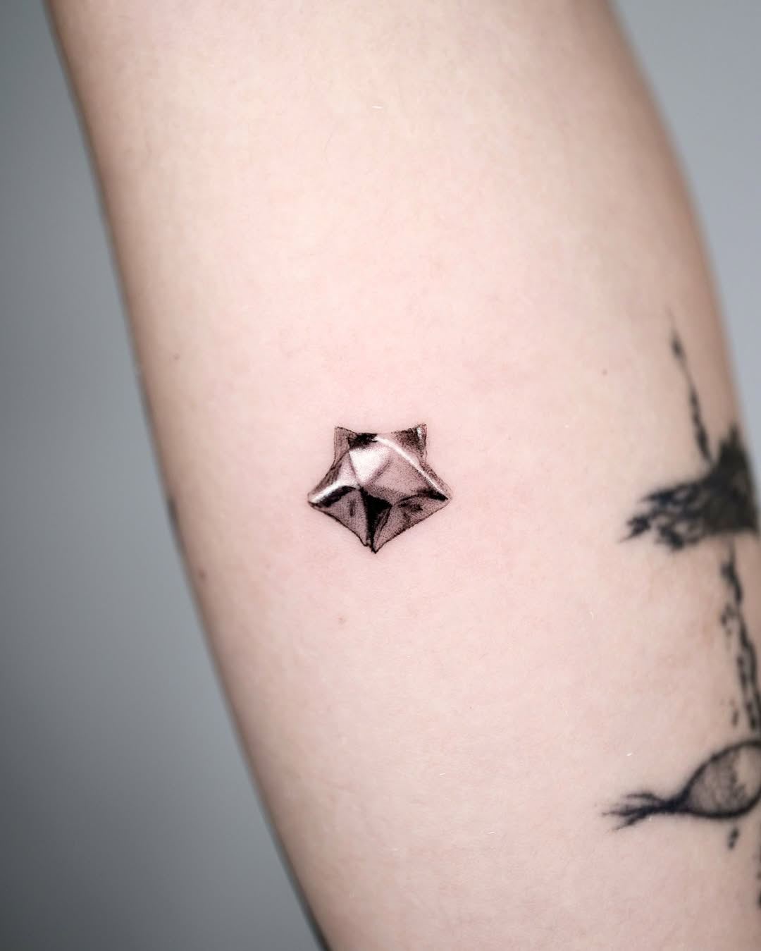 Stylish silver ink star tattoo on arm Tattoo on skin