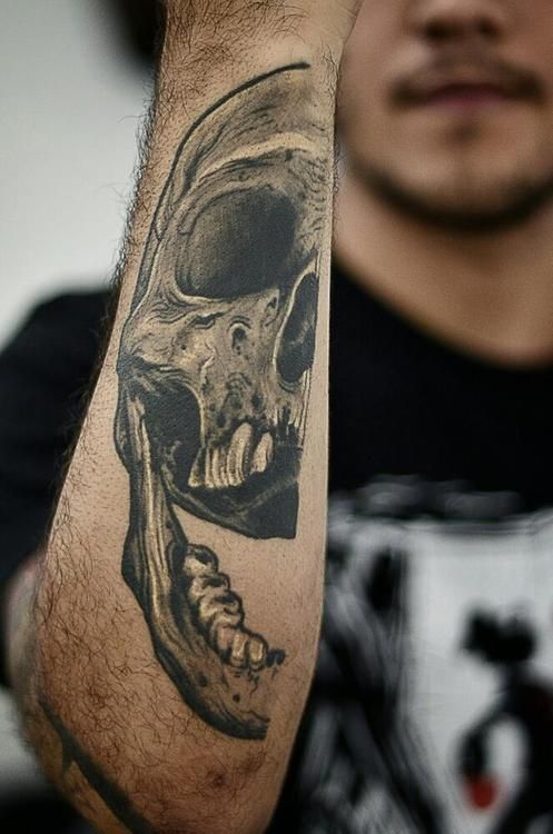 Intriguing skull tattoo on a man’s lower arm Tattoo on skin