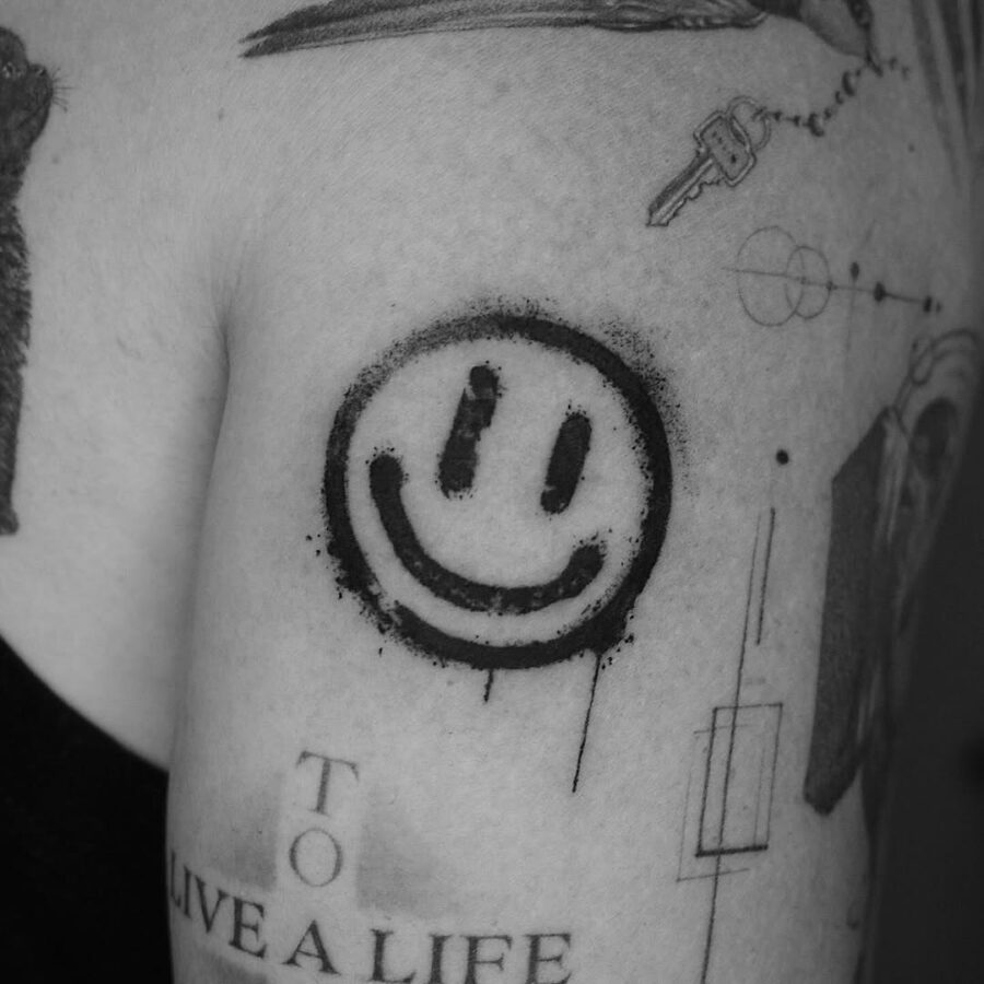 Bold Smiley Face Tattoo in Black Ink Tattoo on skin