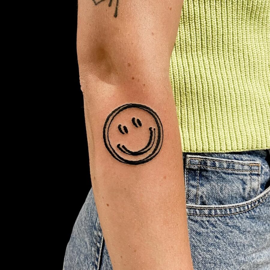 Charming smiley face tattoo radiating positivity Tattoo on skin