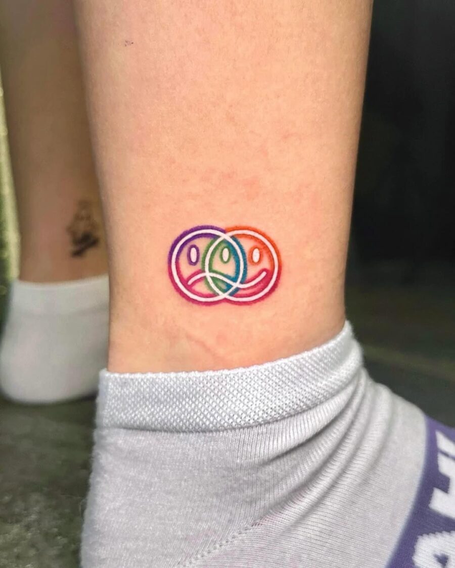 Colorful smiley faces in playful overlapping design Tattoo on skin