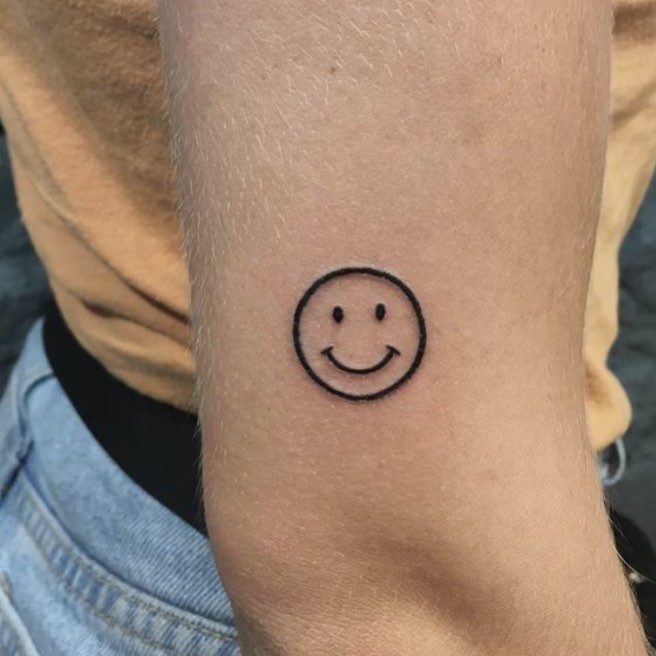 Minimalistic smiley face tattoo on forearm Tattoo on skin