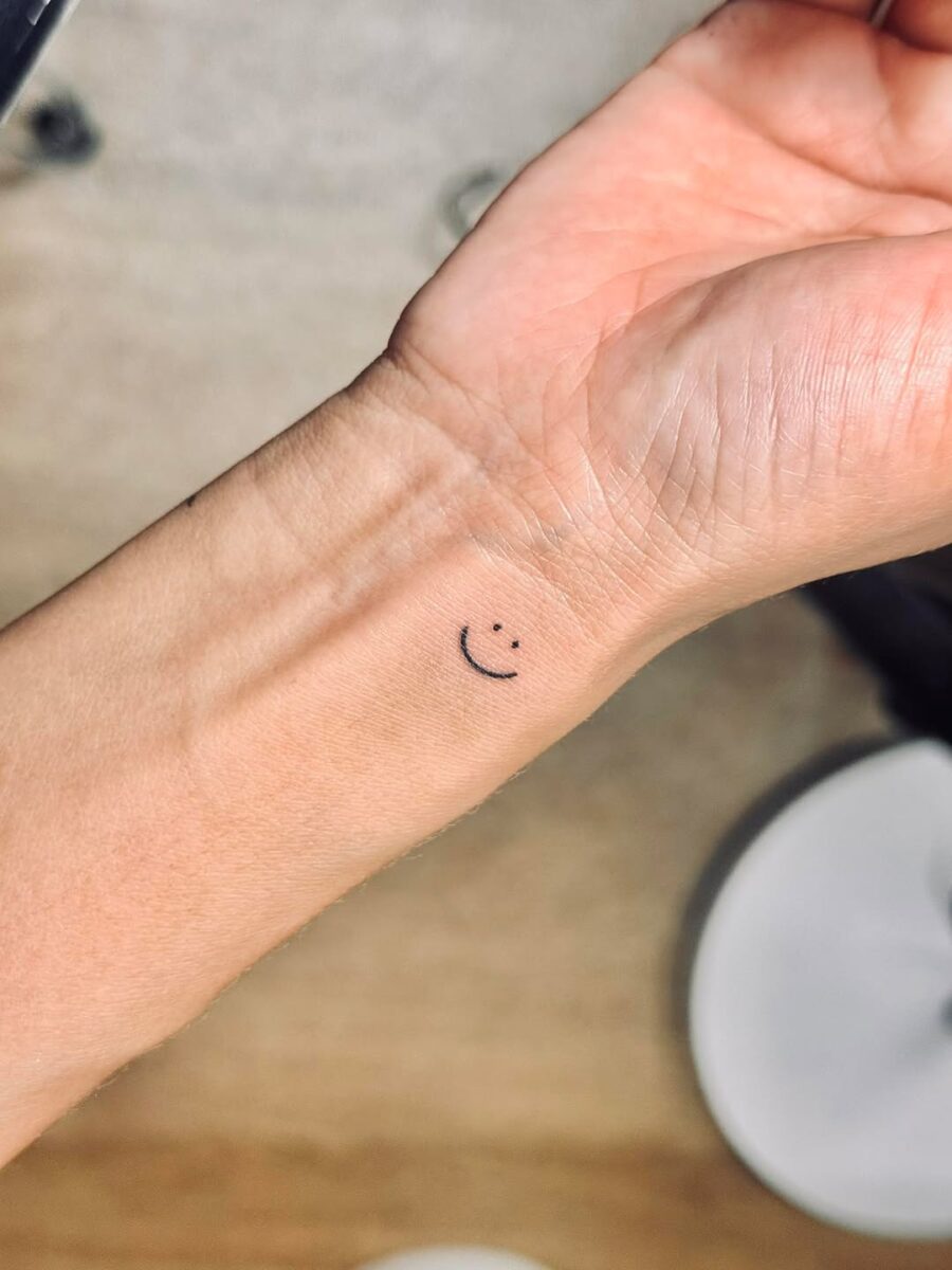 Minimalistic smiley face tattoo on wrist Tattoo on skin