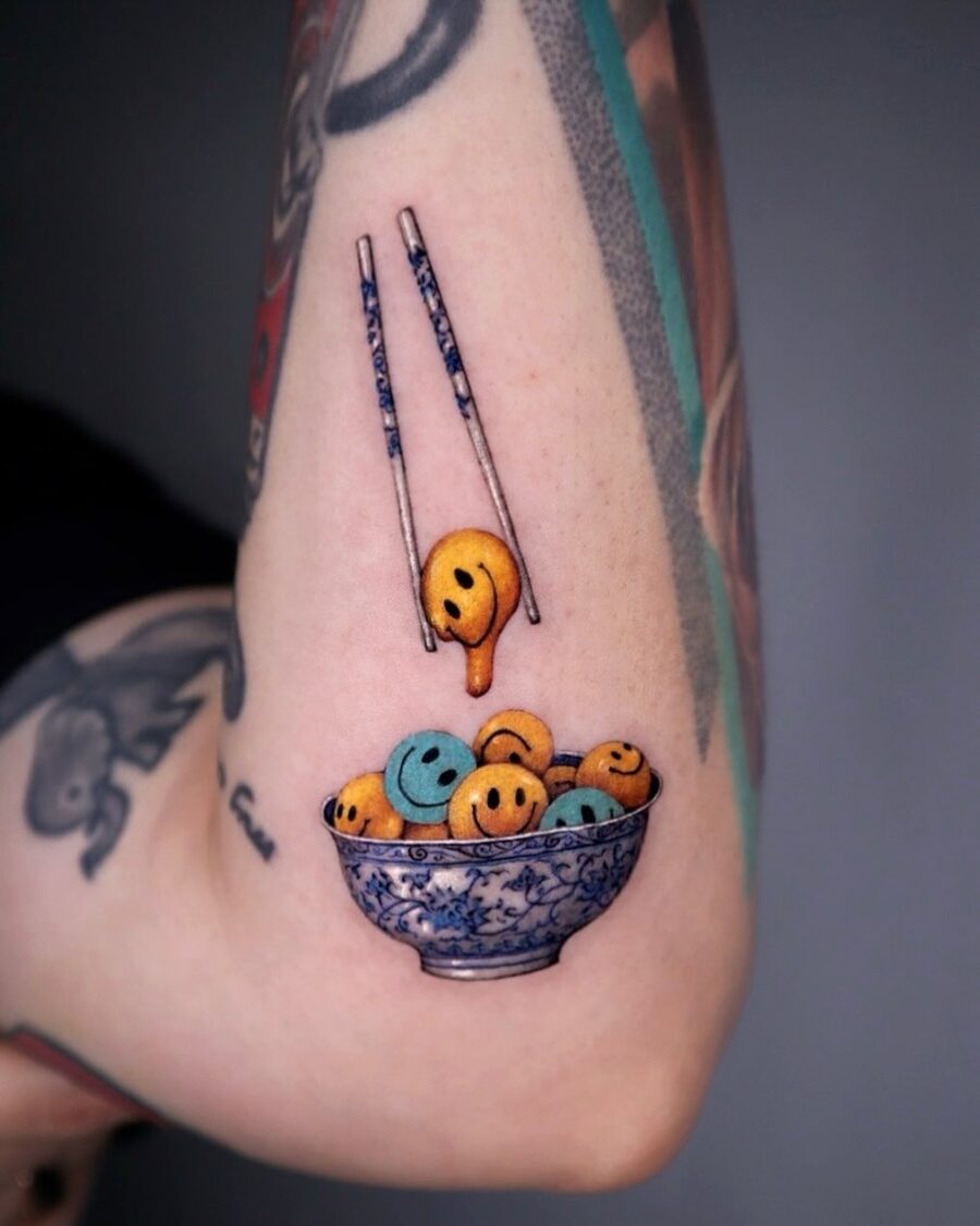 Playful smiley face tattoo with artistic flair Tattoo on skin