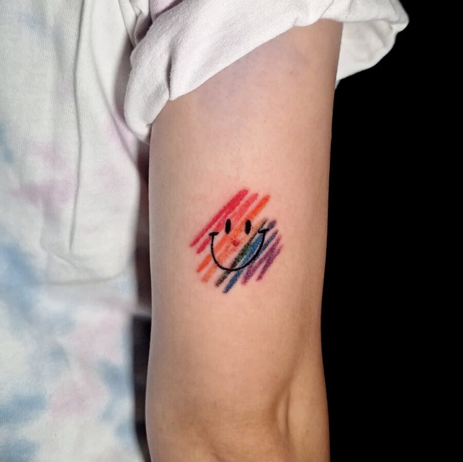 Vibrant Smiley Face Tattoo with a Colorful Splash Tattoo on skin
