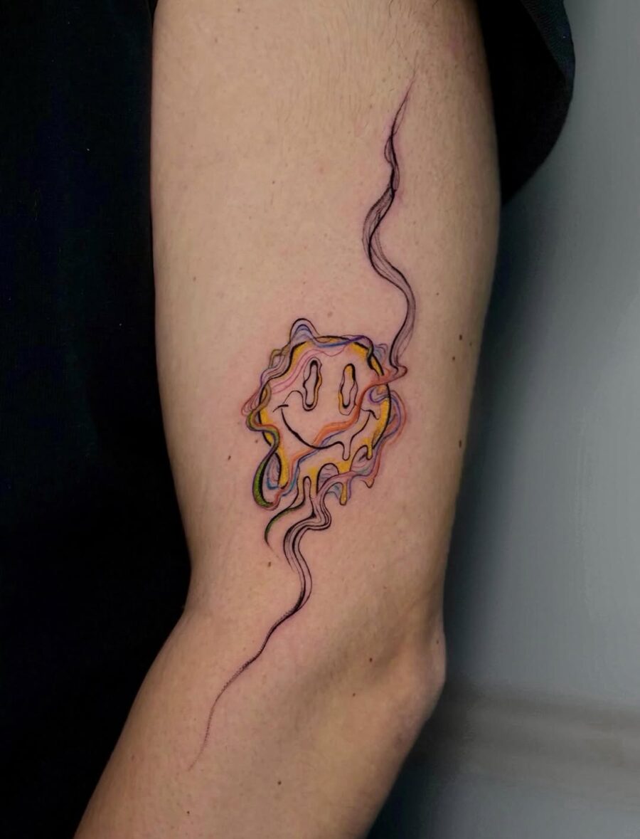 Vibrant Smiley Face Tattoo with Swirling Lines Tattoo on skin