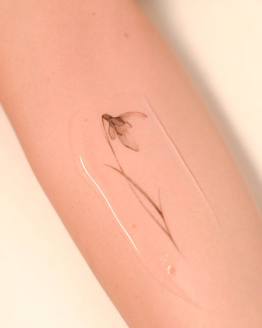 Delicate snowdrop flower tattoo on forearm Tattoo on skin