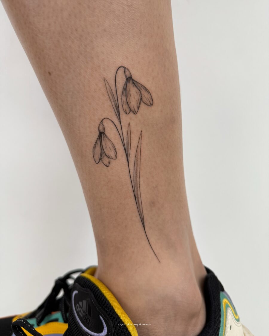 Elegant snowdrop tattoo adorned on the leg Tattoo on skin