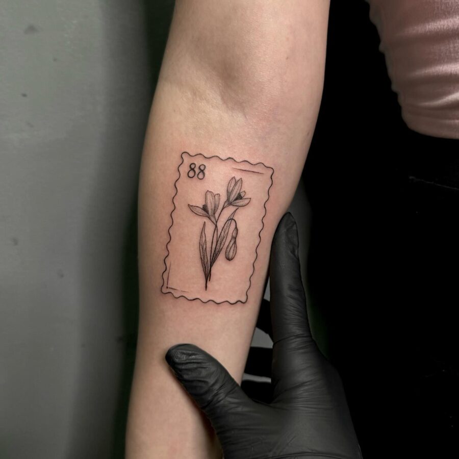 Elegant snowdrop tattoo in stamp design Tattoo on skin