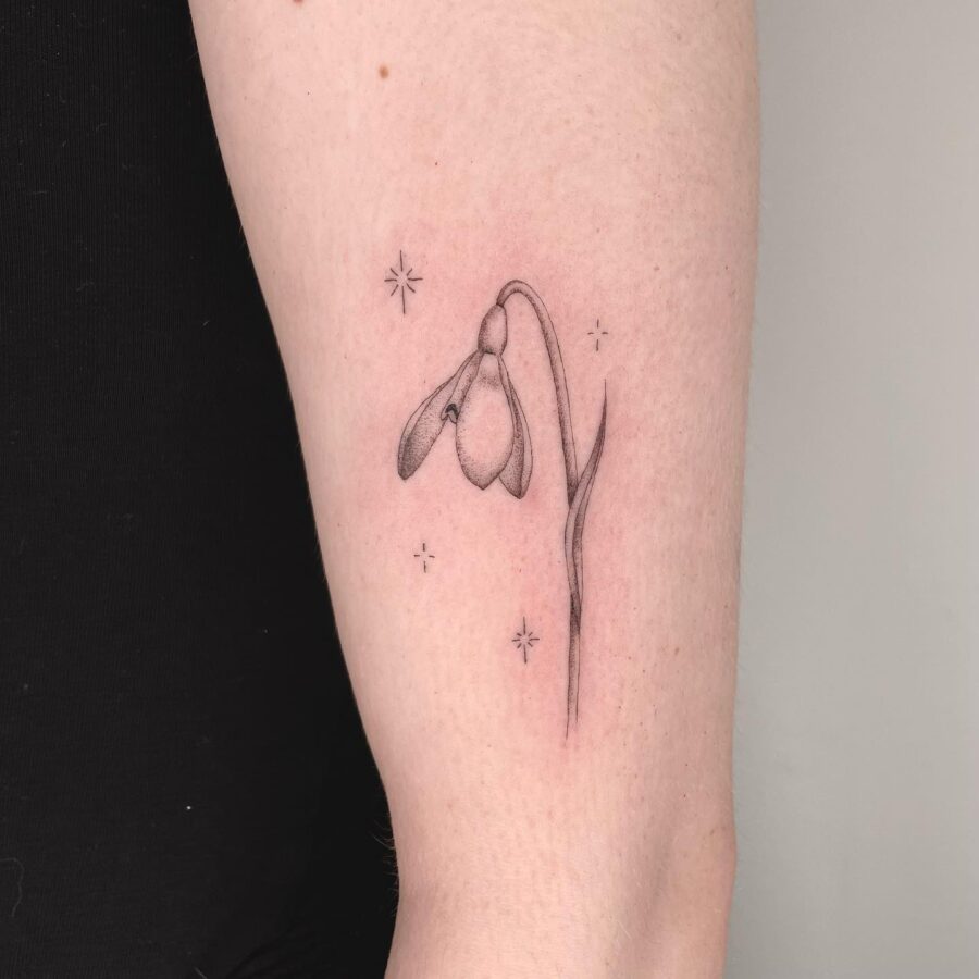 Elegant snowdrop tattoo with celestial accents Tattoo on skin