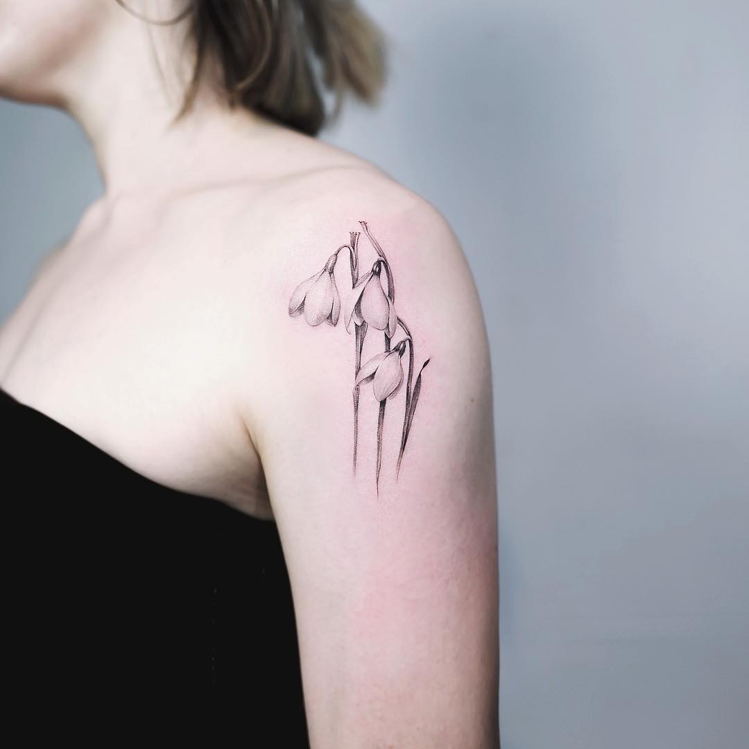 Intricate snowdrop flower tattoo on the shoulder Tattoo on skin