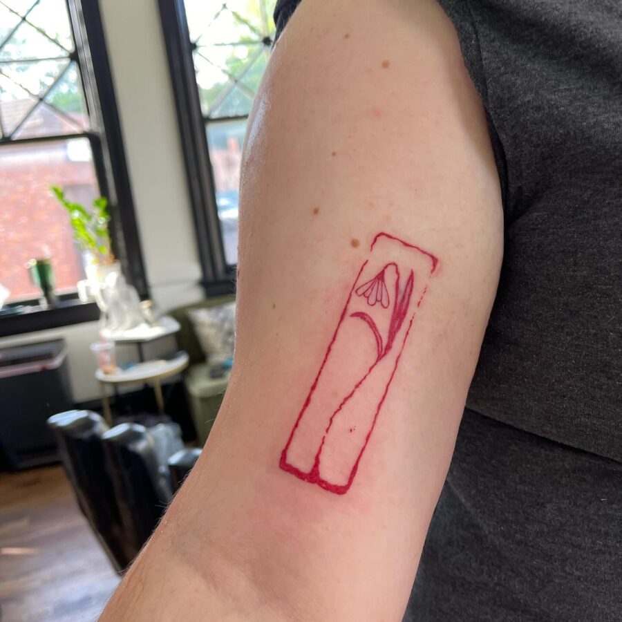Minimalist snowdrop tattoo on arm. Tattoo on skin