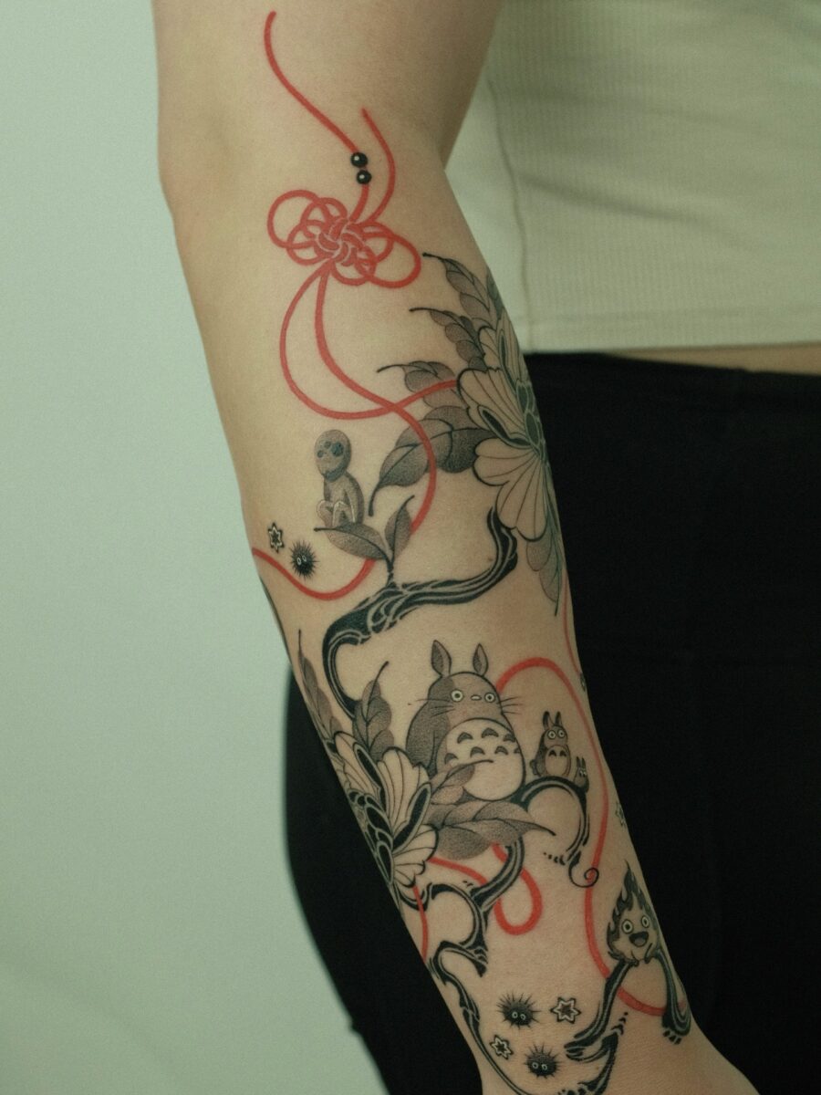 A whimsical Totoro tattoo design with flowers Tattoo on skin