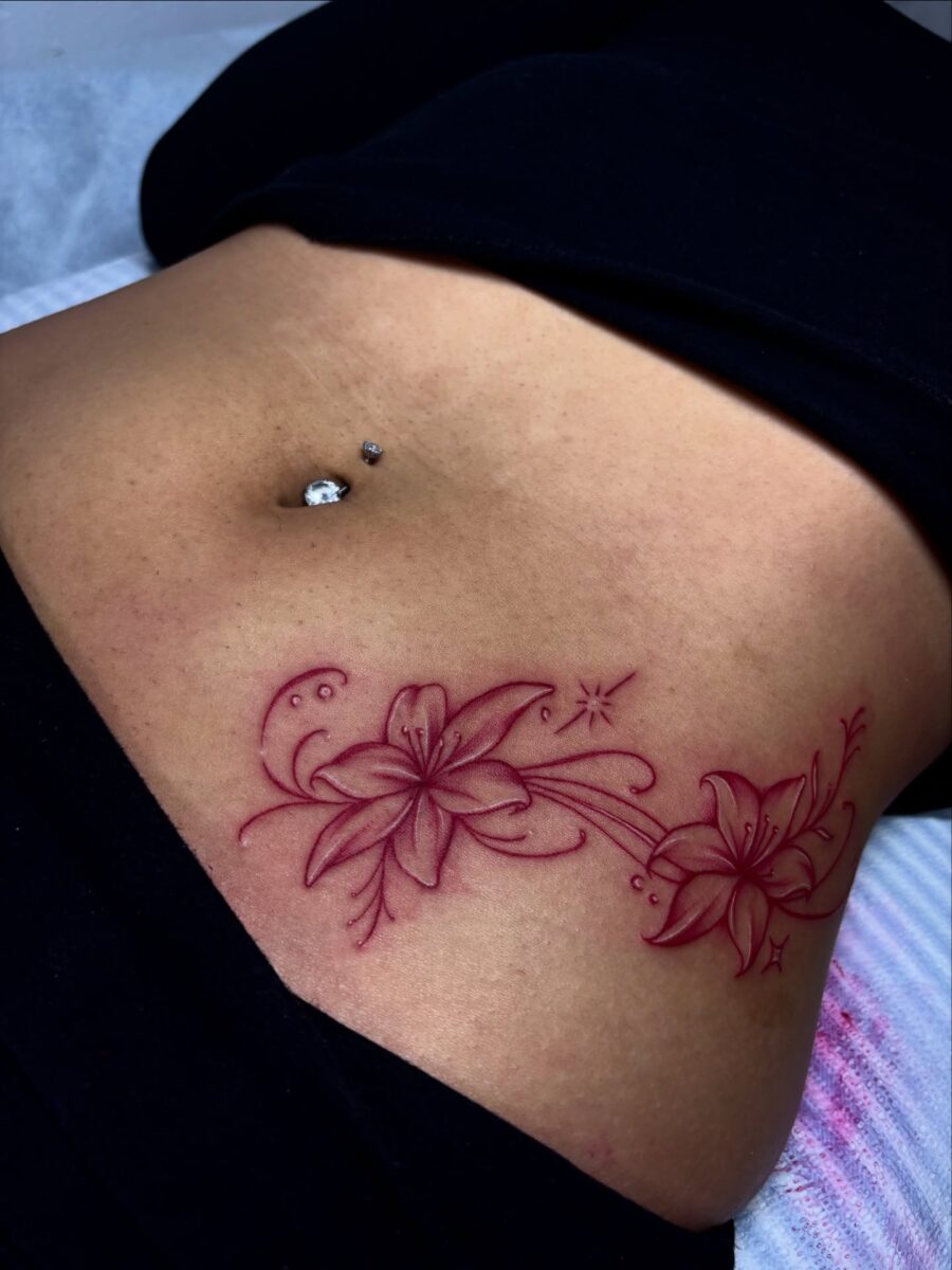 Elegant floral stomach tattoo in vibrant red Tattoo on skin