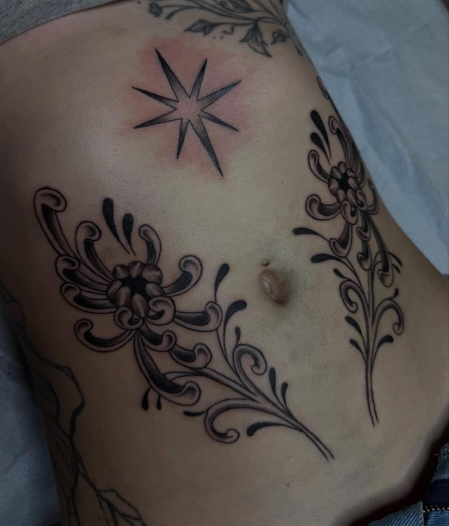 Elegant floral stomach tattoo with star detail Tattoo on skin