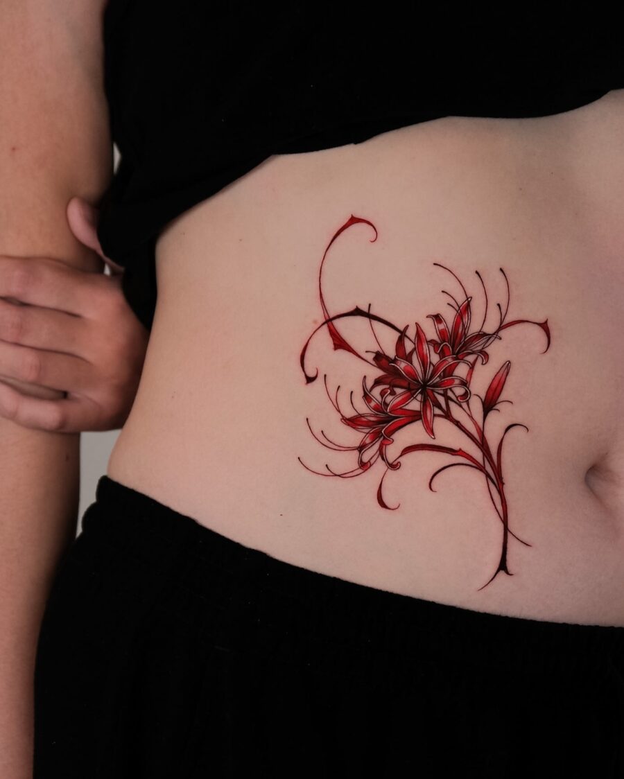 Vibrant floral stomach tattoo in red hues Tattoo on skin