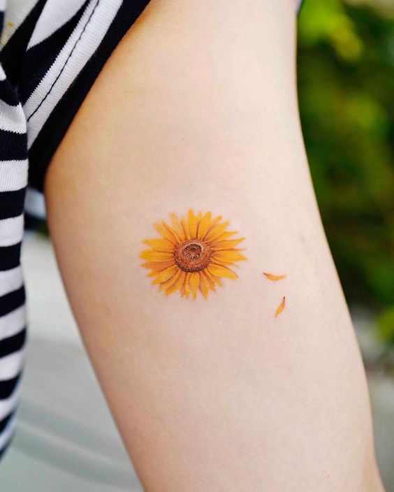 Delicate Colored Sunflower Tattoo Ideas with Floating Petals Tattoo on skin