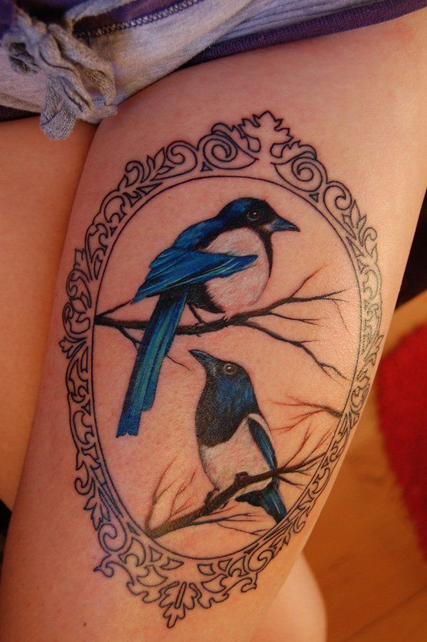 A crown tattoo with birds in it on the thighs Tattoo on skin