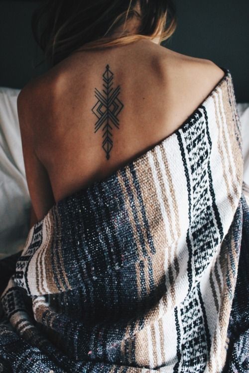 A small Tribal Tattoo on a woman's back Tattoo on skin