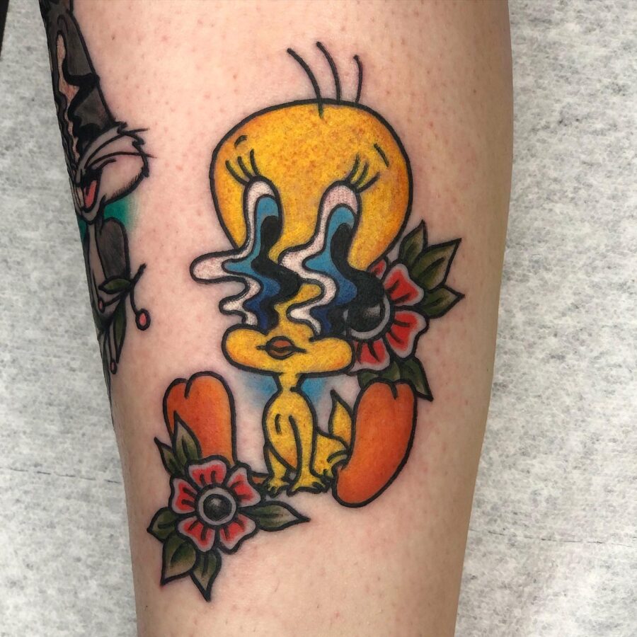 Vibrant Tweety Tattoo Surrounded by Flowers Tattoo on skin