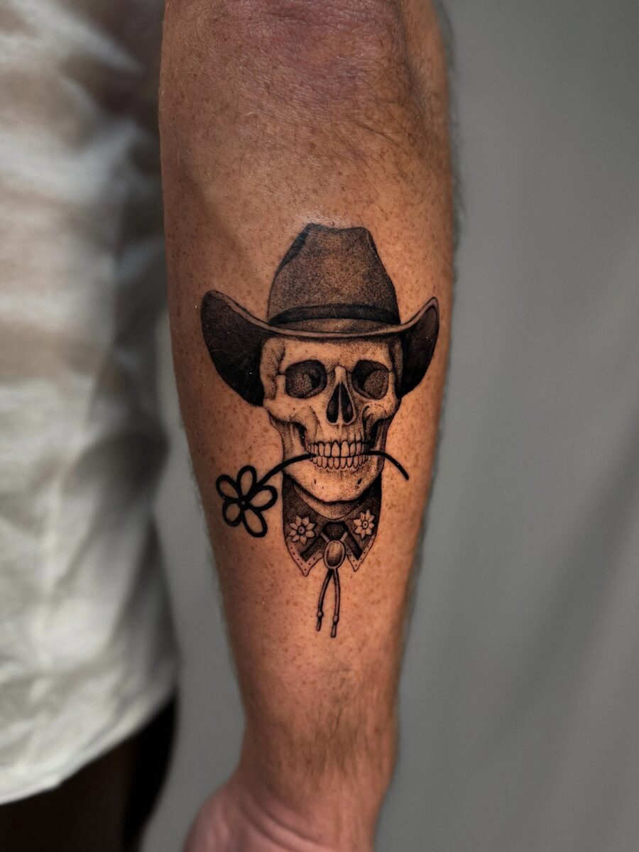 Classic cowboy skull tattoo with floral detail Tattoo on skin