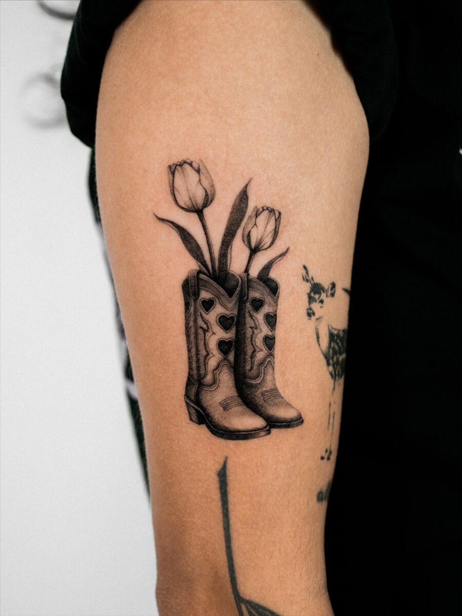 Creative fusion of boots and floral elements western tattoos