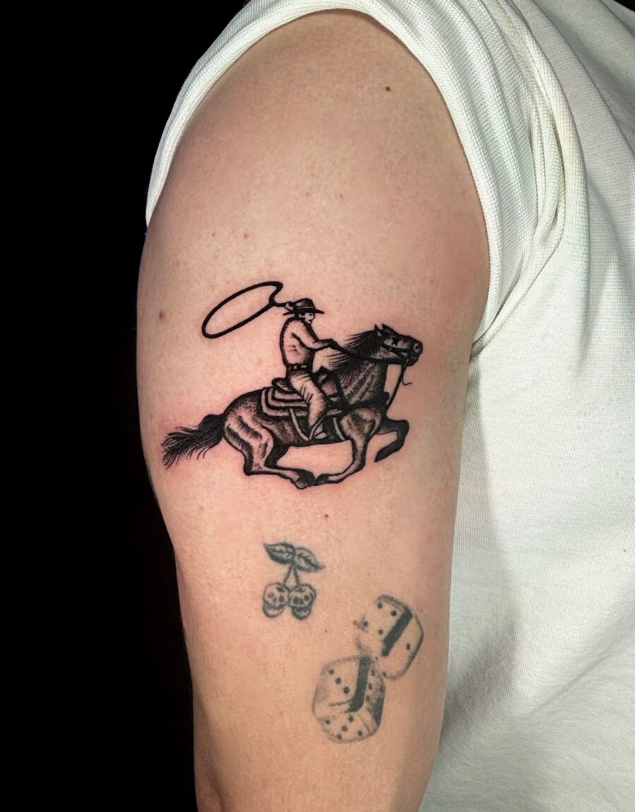 Dynamic western tattoo of cowboy on horseback Tattoo on skin