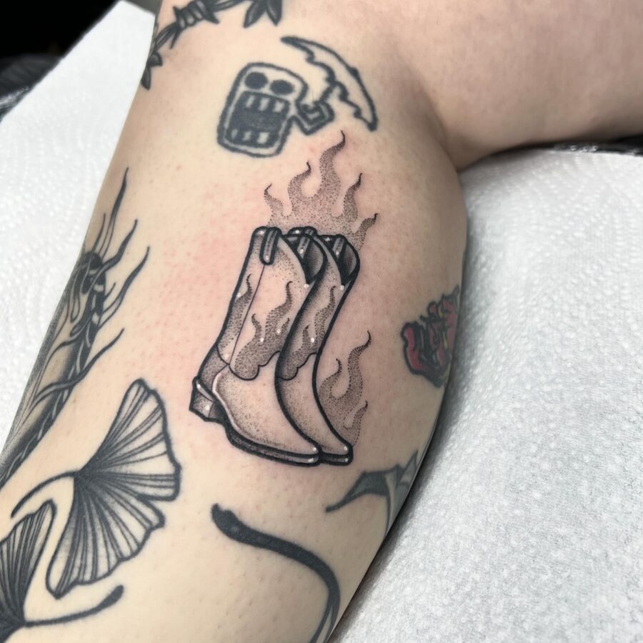 Flaming Cowboy Boots Tattoo Symbolizing Adventure Tattoo on skin