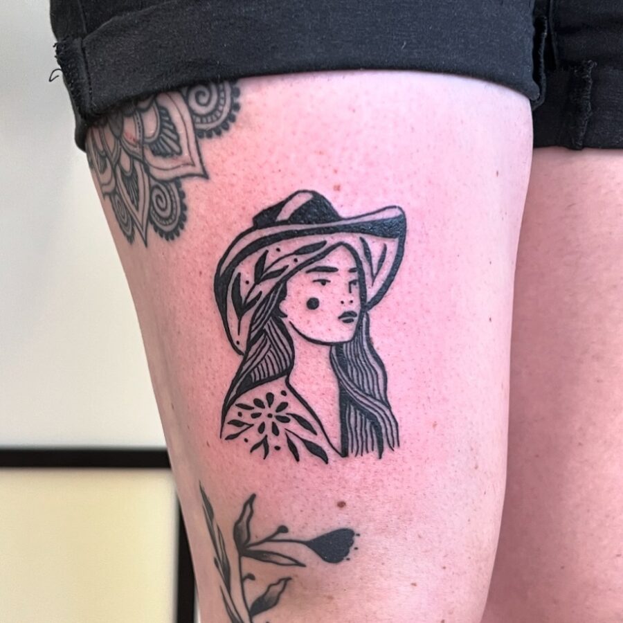 Stylish cowgirl tattoo with floral elements Tattoo on skin