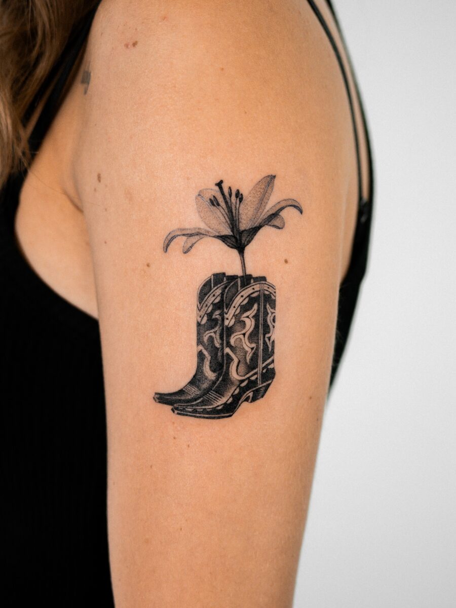 Stylish western boot tattoo with floral accents Tattoo on skin