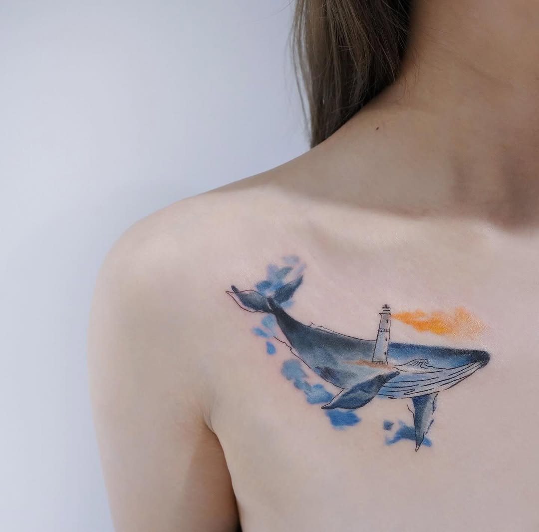 A vibrant whale tattoo with lighthouse detail Tattoo on skin