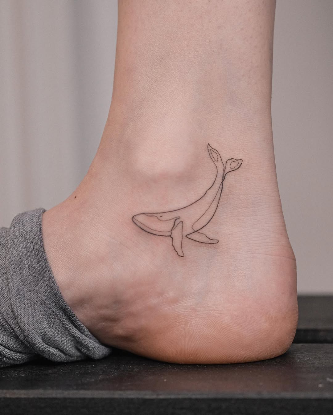 Charming Minimalist Whale Tattoo on the Ankle Tattoo on skin