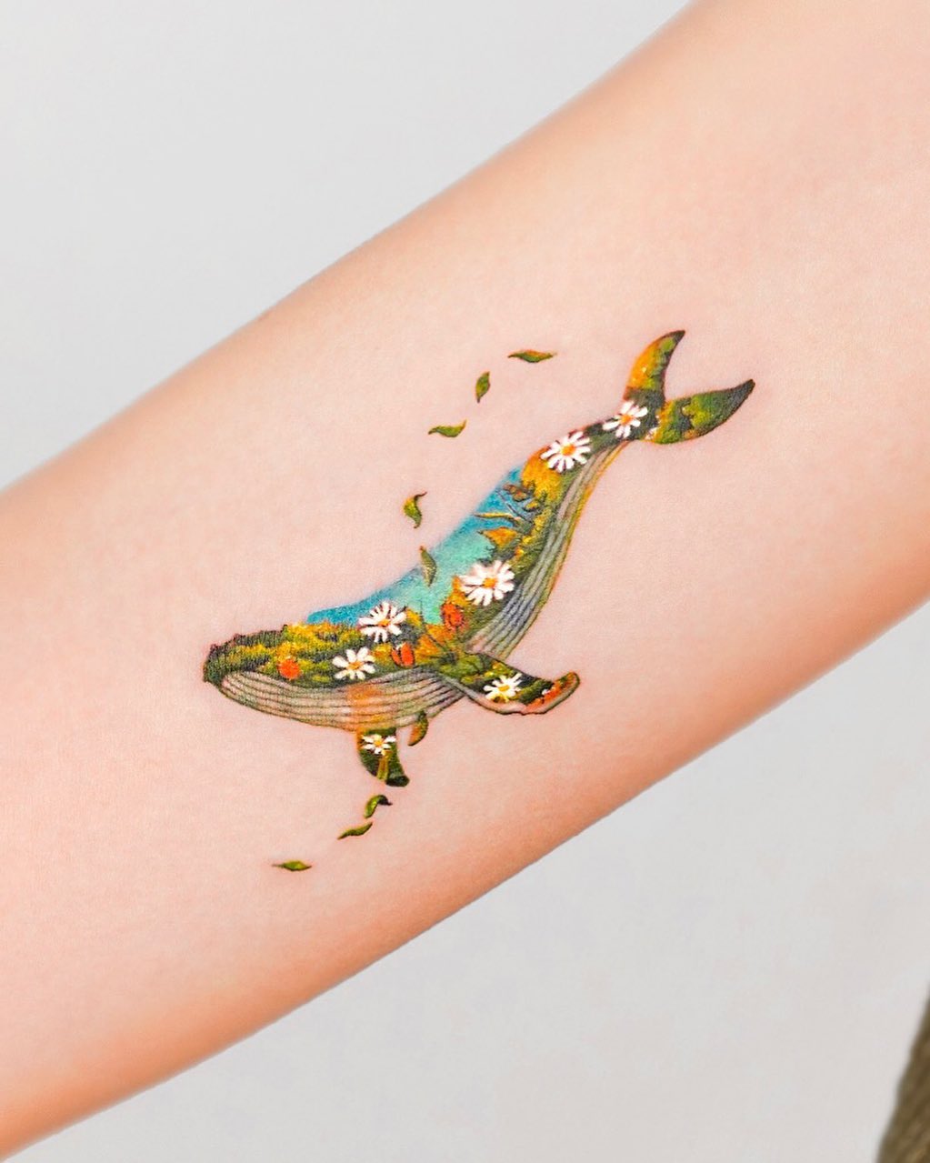 Colorful floral whale tattoo on the arm Tattoo on skin
