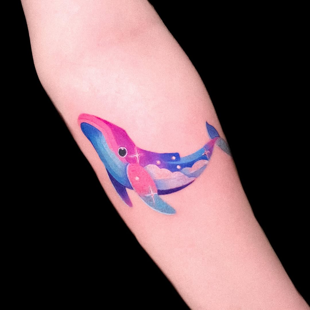 Vibrant whale tattoo with cosmic elements Tattoo on skin