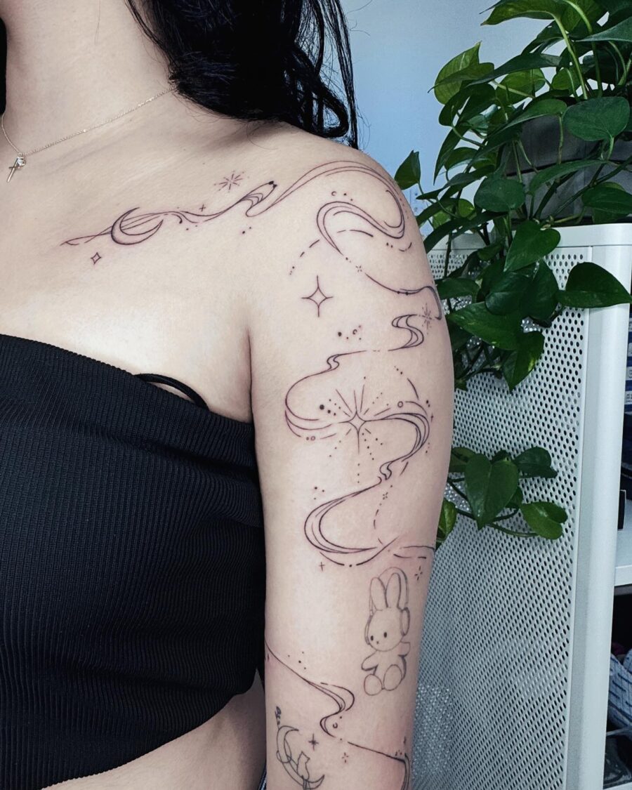 Magical swirls and playful characters adorn skin. Tattoo on skin