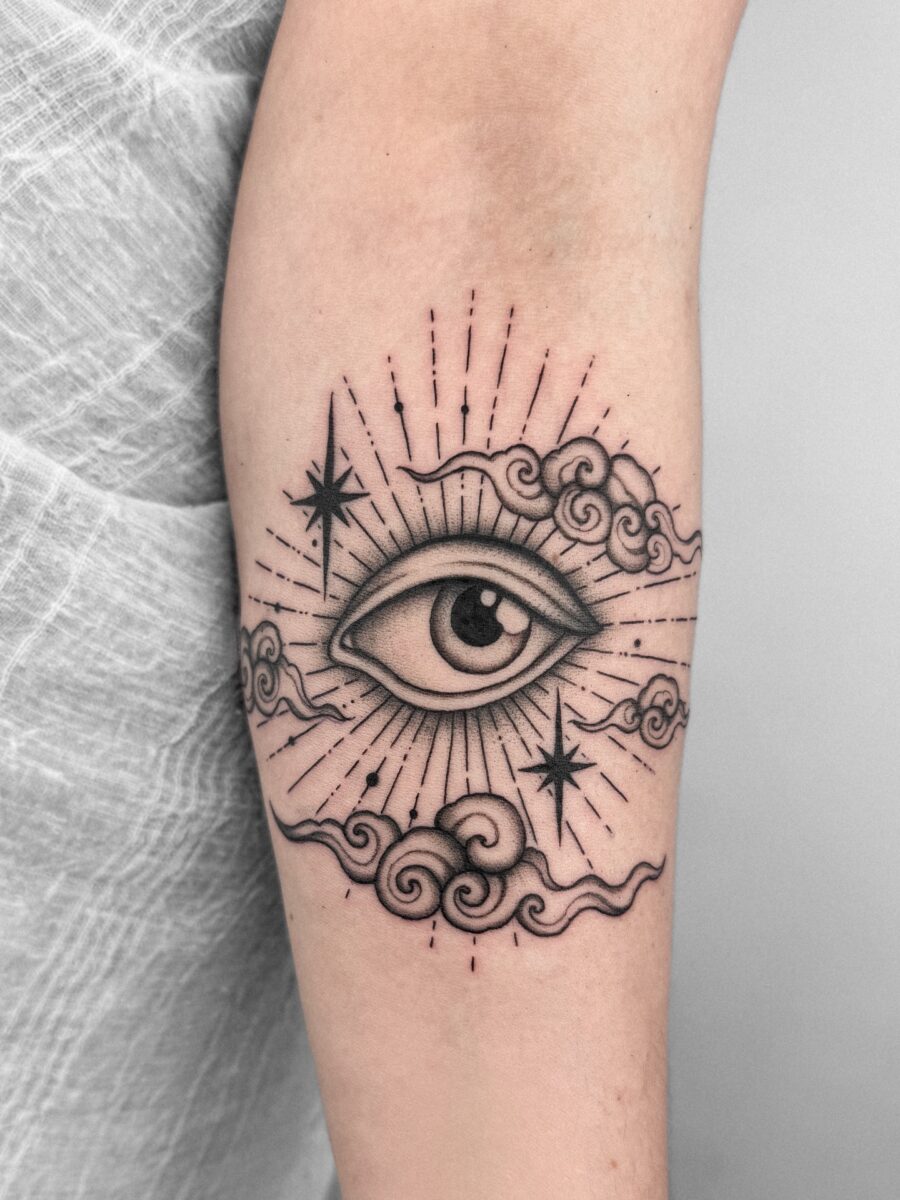 Whimsical Eye Tattoo Surrounded by Cosmic Elements Tattoo on skin