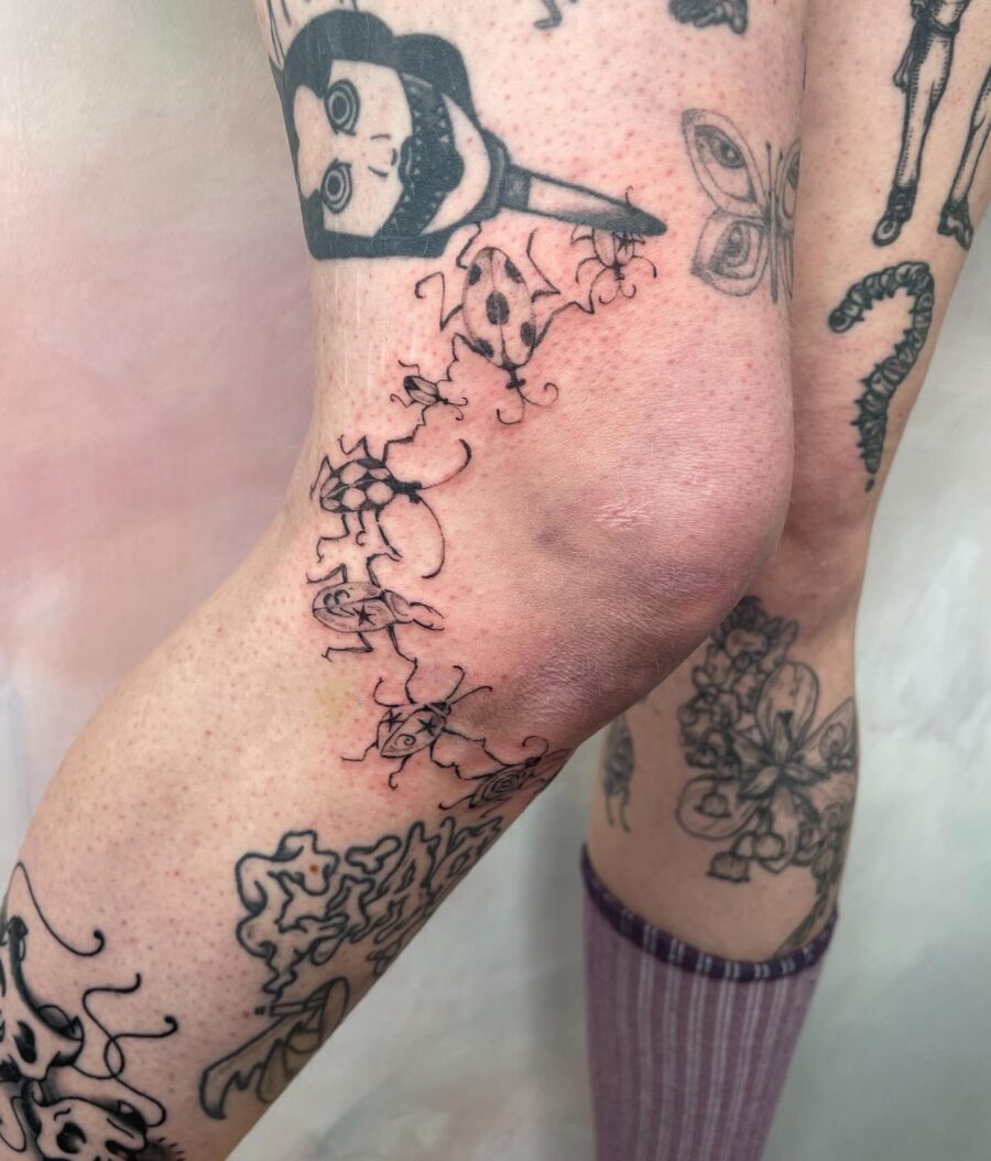 Whimsical knee tattoos with floral elements Tattoo on skin