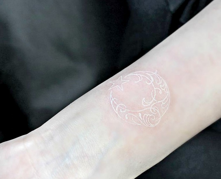 Celestial White Ink Tattoo Design with Flourish Embellishments Tattoo on skin