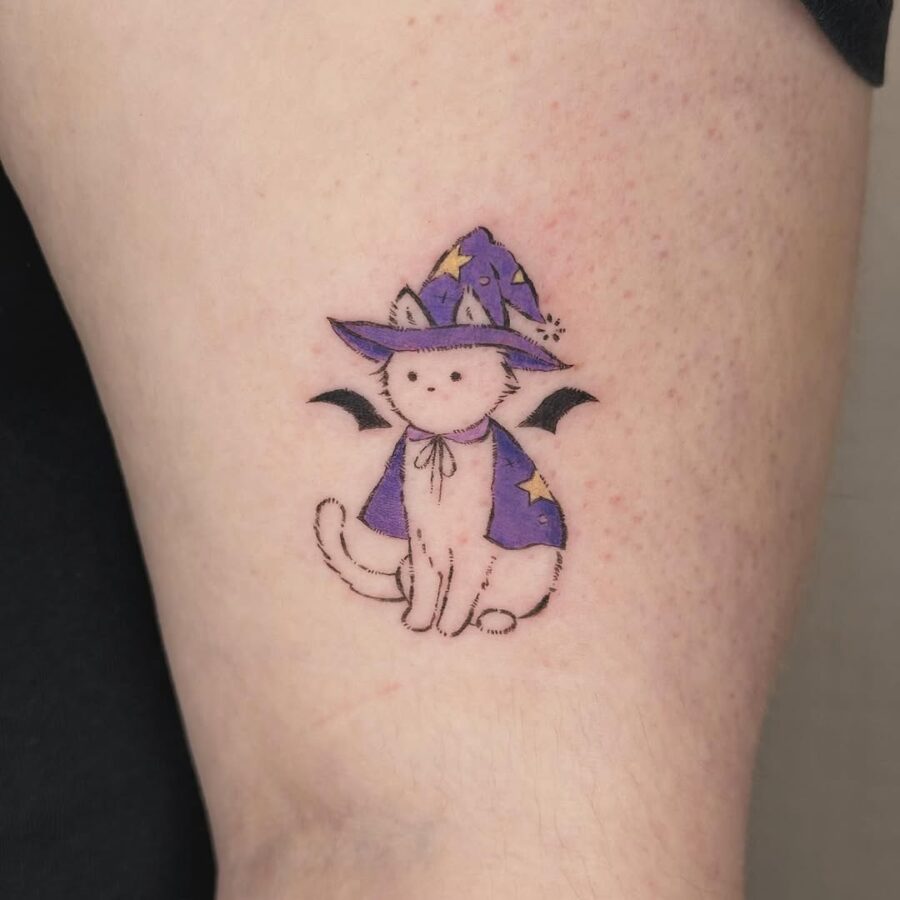Adorable cat with a whimsical witch hat tattoo Tattoo on skin