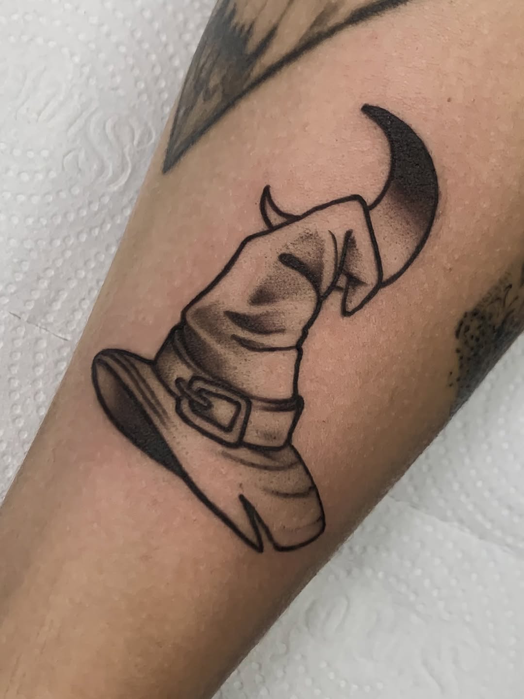 Chic black witch hat tattoo with subtle shading Tattoo on skin