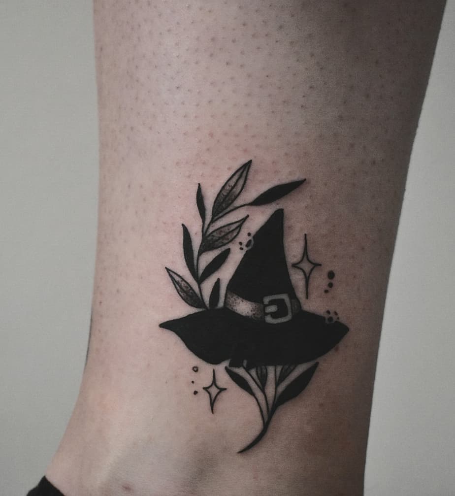 Stylish witch hat tattoo with floral elements Tattoo on skin