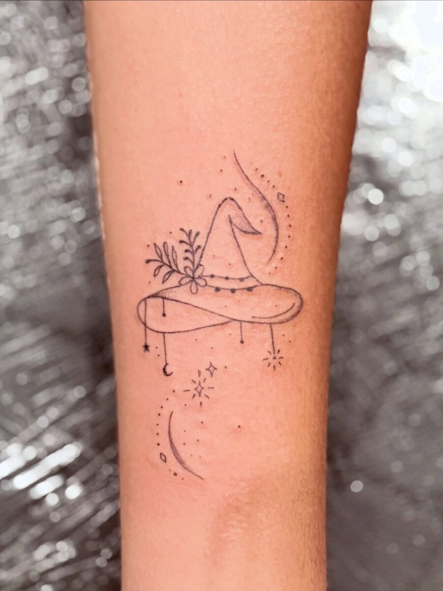 Whimsical witch hat adorned with nature and stars Tattoo on skin