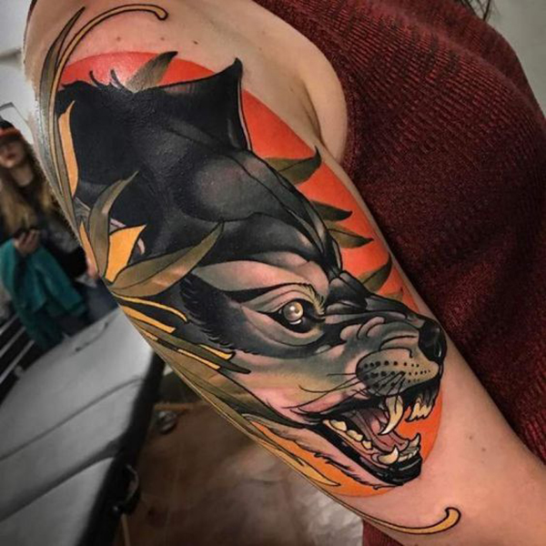 Snarling Silver Wolf against an Orange Sunset Tattoo on skin