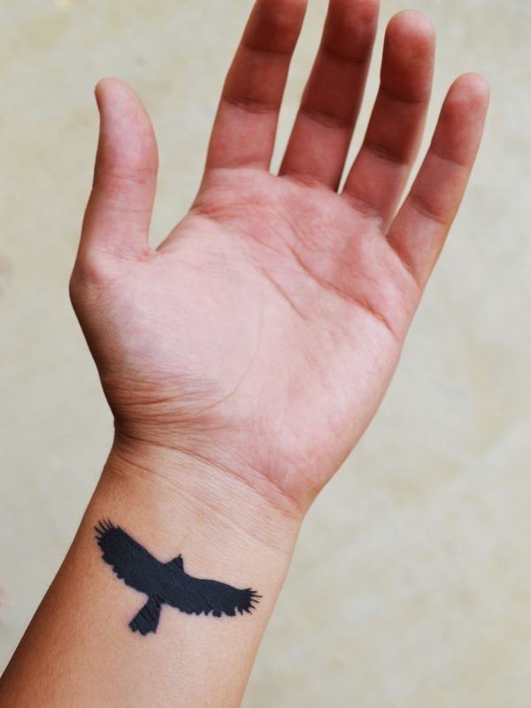 A big black Bird Wrist Tattoo Tattoo on skin